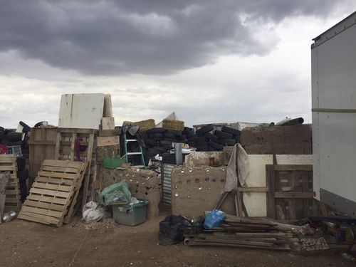This Friday, Aug. 3, 2018, photo released by Taos County Sheriff's Office shows a rural compound during an unsuccessful search for a missing 3-year-old boy in Amalia, N.M. Law enforcement officers searching the compound for the missing child didn't locate him but found 11 other children in filthy conditions and hardly any food, a sheriff said Saturday. The children ranging in age from 1 to 15 were removed from the compound and turned over to state child-welfare workers, Taos County Sheriff Jerry Hogrefe said.in Taos, N.M. (Taos County Sheriff's Office via AP)