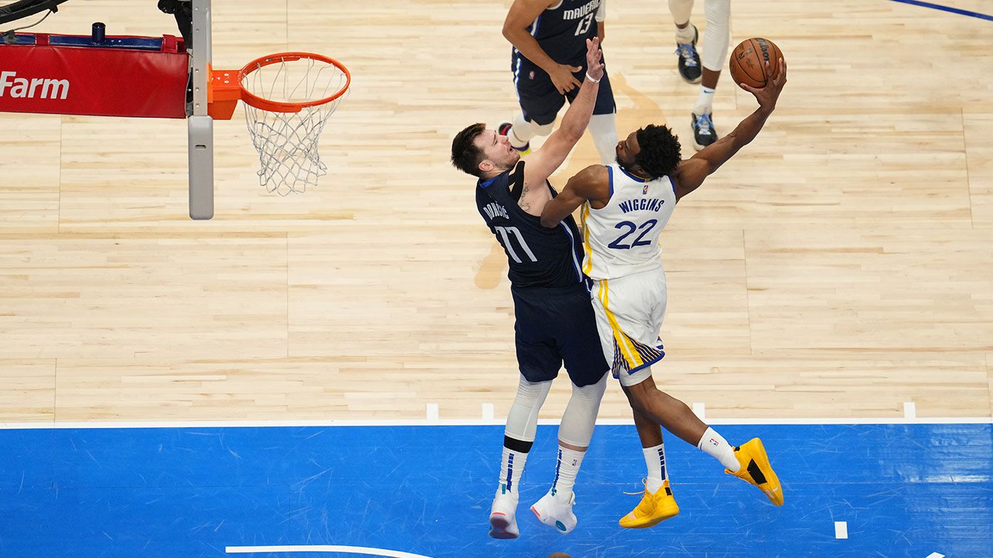 Andrew Wiggins #22 of the Golden State Warriors dunks on Luka Doncic