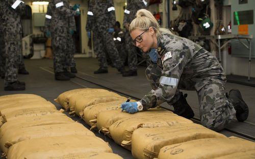 Leading Seaman Naval Police Coxswain Jamie Janes as she numbers narcotic parcels seized by HMAS Warramunga during operations in the Middle East in December last year. (AAP)