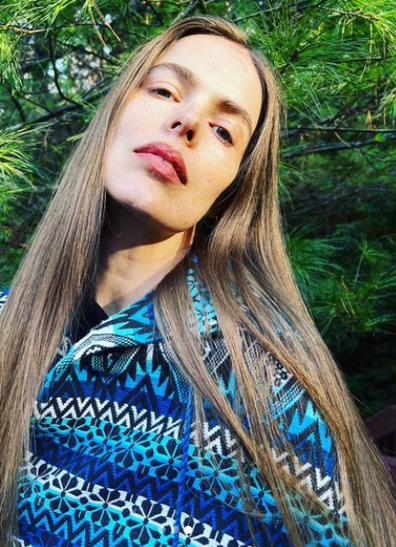 Model, Robyn Lawley, wearing blue patterned print jumper with long, straight, light brown hair out.