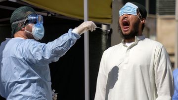 A man has a swab being taken to test for COVID-19 outside a healthcare center in Rome.