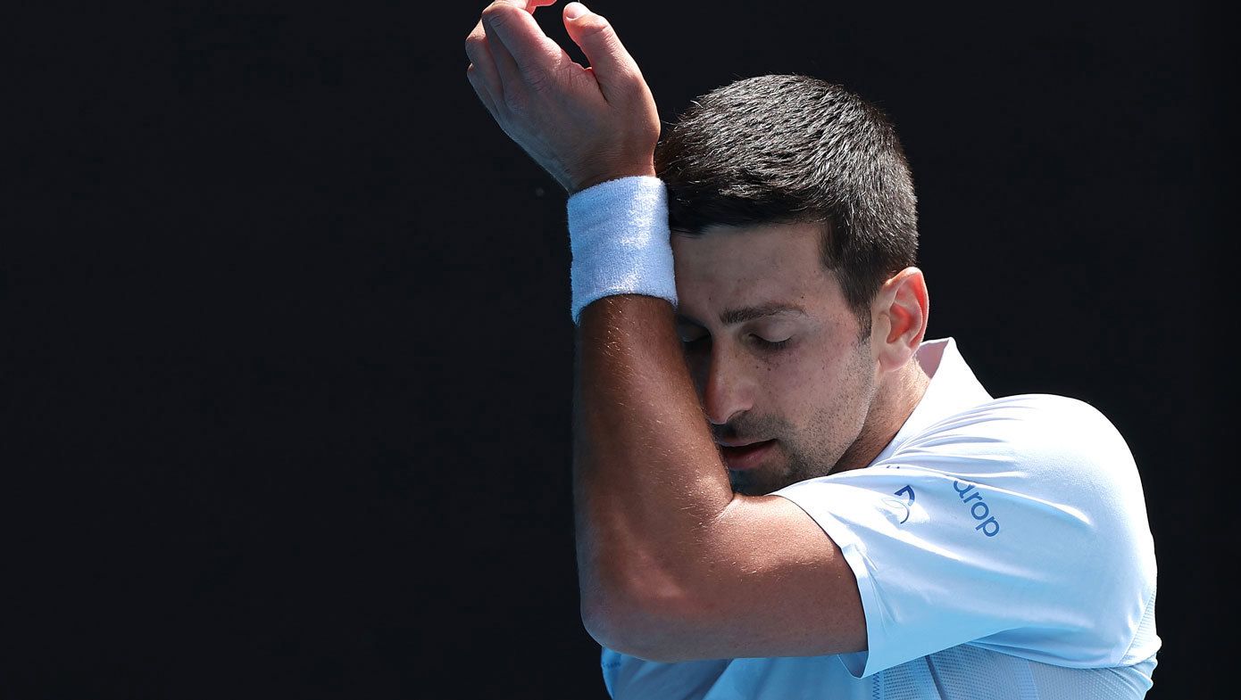 Novak Djokovic wipes his brow early in the first set of his match against Jannik Sinner.