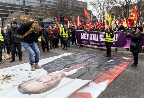 A protestor prepares to jump on a banner with the image of Turkish President Recep Tayyip Erdogan during a demonstration organised by The Kurdish Democratic Society Center in Sweden.