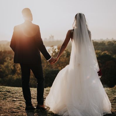 Bride and groom holding hands.