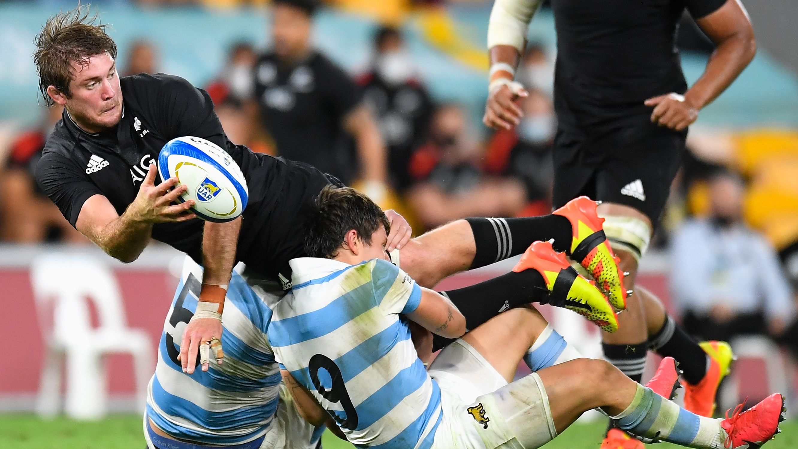 Ethan Blackadder of the All Blacks offloads the ball in a tackle.