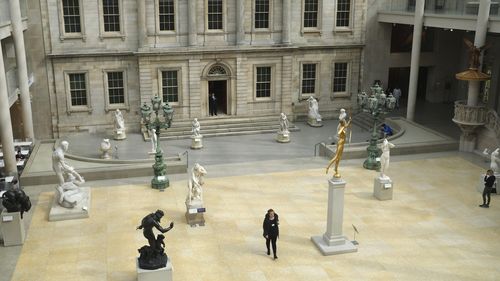 A few visitors walk through an exhibit of American art at the Metropolitan Museum of Art in New York, Tuesday, March 10, 2020. 