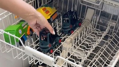 Toy cars in the top rack of a dishwasher for cleaning