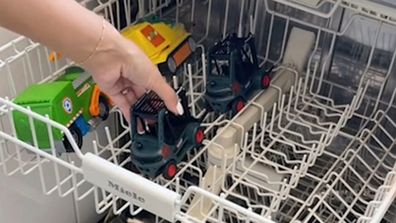 Toy cars in the top rack of a dishwasher for cleaning