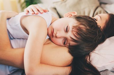 Mother and son asleep in bed