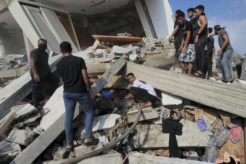 Palestinians look for survivors in the rubble of a destroyed building following an Israeli airstrike in Bureij refugee camp, Gaza Strip, Thursday, Nov. 2, 2023.