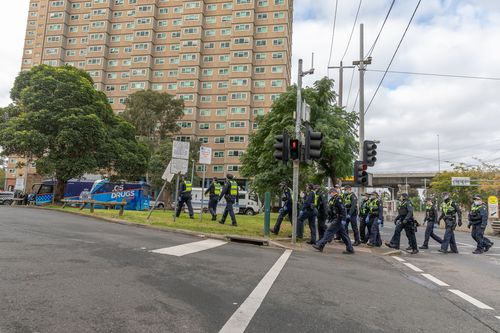 Protective service police officers walk towards the Flemington Public housing flats
