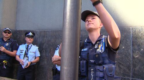 Constable Mairead Devlin raising the flag. (9NEWS)