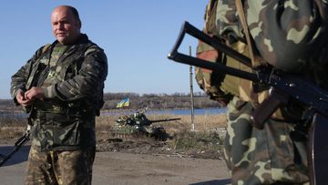 Army officials stand guard at a checkpoint in the Karlovka village, near Donetsk, Ukraine. (AAP)