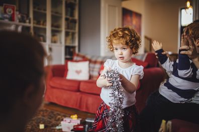 A little girl holds tinsel