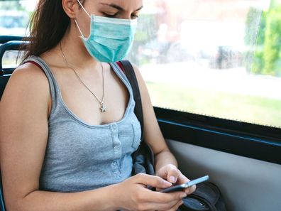 Young woman wearing face mask on public transport.