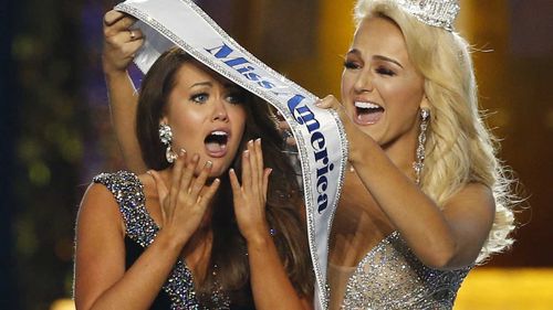 Cara Mund is given the Miss America sash by the previous winner.