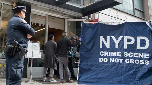 New York police officers set up a tent to prevent reporters from view as they remove bodies from the Gotham Hotel. Picture: AP