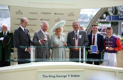 Owners of Desert Hero, King Charles III and Queen Camilla collect the winners trophy for The King George V Stakes alongside trainer William Haggas, and jockey Tom Marquand  during day three of Royal Ascot 2023 at Ascot Racecourse on June 22, 2023 in Ascot, England 