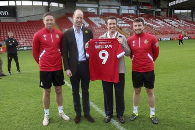 Prince William, Prince of Wales poses for a photograph with Chairman of Wrexham AFC Rob McElhenney, center right, and players Ben Tozer, left, and club captain Luke Young on the pitch at the Racecourse Ground, the home of Wrexham AFC in Wrexham, Wales, Friday March 1, 2024, to mark St. David's Day. 