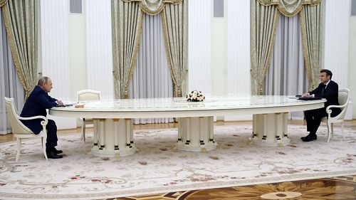 Macron and Putin sat six metres apart at the table.