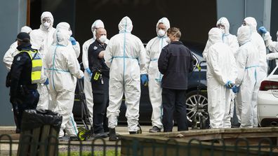 Workers in personal protective equipment are seen, along side police patrols, on July 07, 2020 in Melbourne, Australia. Nine public housing estates are in mandatory lockdown, with restrictions returning across the rest of the city.