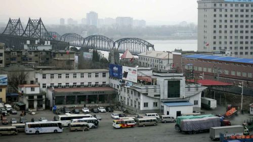 Loaded trucks and vehicles wait in line at the border checkpoint before crossing the Friendship Bridge linking China and North Korea. (AAP)