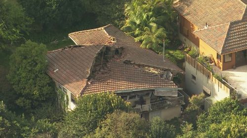 The roof of a house in Sydney has completely collapsed and caved in on itself.