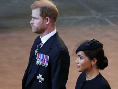 LONDON, ENGLAND - SEPTEMBER 14: Prince Harry, Duke of Sussex and Meghan, Duchess of Sussex walk as procession with the coffin of Britain's Queen Elizabeth arrives at Westminster Hall from Buckingham Palace for her lying in state, on September 14, 2022 in London, United Kingdom. Queen Elizabeth II's coffin is taken in procession on a Gun Carriage of The King's Troop Royal Horse Artillery from Buckingham Palace to Westminster Hall where she will lay in state until the early morning of her funeral.