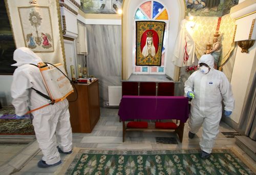 Workers wearing protective clothing disinfect St Antonio Church, in Bayrakli district of Izmir, Turkey. Picture: Emre Tazegul