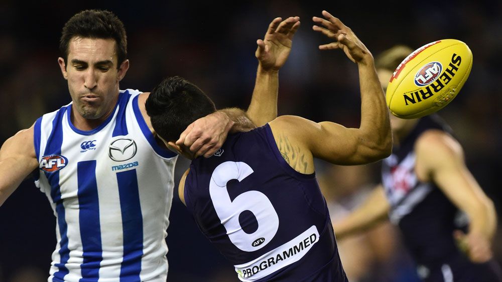 North Melbourne's Michael Firrito (left) makes a high tackled on Fremantle Dockers player Danyle Pearce. (AAP) 