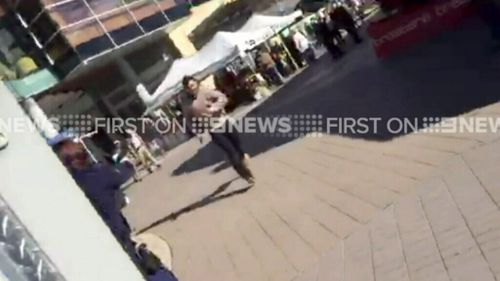 The man approaches a police officer before the shooting. (9NEWS)