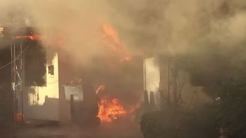 Fire engulfs the home in Fresno, California where an elderly man was rescued. (YouTube)