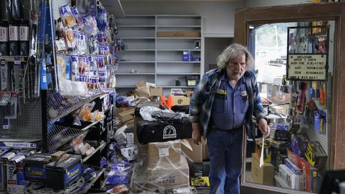 Kenny Ransbottom traverse des débris à l'intérieur de son magasin de pièces automobiles après un tremblement de terre à Rio Dell, en Californie, le mardi 20 décembre 2022. 