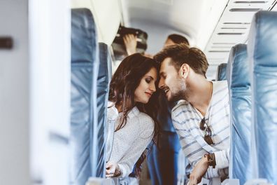 Loving young couple sitting in the airplane.