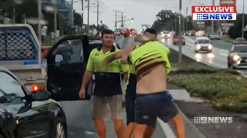 Two tradesmen were filmed on a dash cam throwing punches towards another driver, who fell to the ground twice.