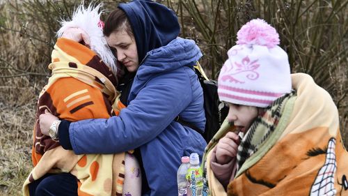 A mother hugs her daughter at a checkpoint run by local volunteers after arriving from Ukraine, crossing the border in Beregsurany, Hungary.