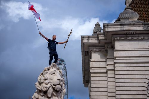 Os manifestantes ondulam Union Jack e as bandeiras da Inglaterra de St. George durante o 