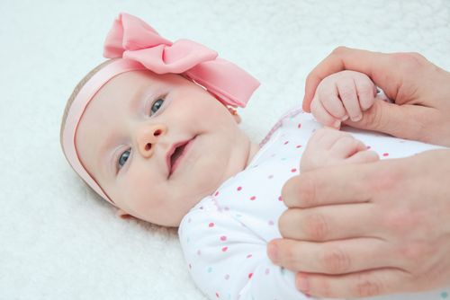 Adorable Baby Girl with Pink Hair Band and Mother Hands