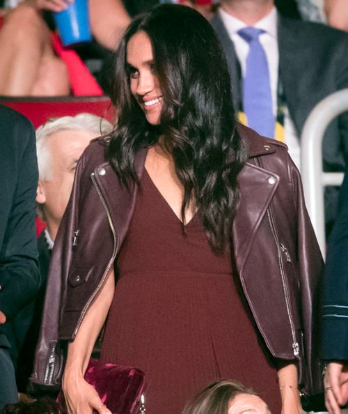 Meghan Markle wore a burgundy jacket over a dark dress. (AAP) 