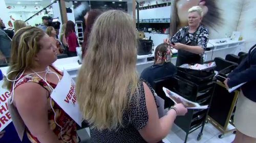 Customers donning signs express their displeasure at a discount beauty salon in Queensland. (A Current Affair)