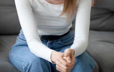 Woman contemplating sitting on couch