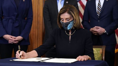 The Speaker of the House of Representatives, Nancy Pelosi, signs the articles of impeachment.