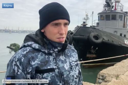 One of the three captured Ukrainian sailors shown on Russian state TV in front of a seized naval ship.