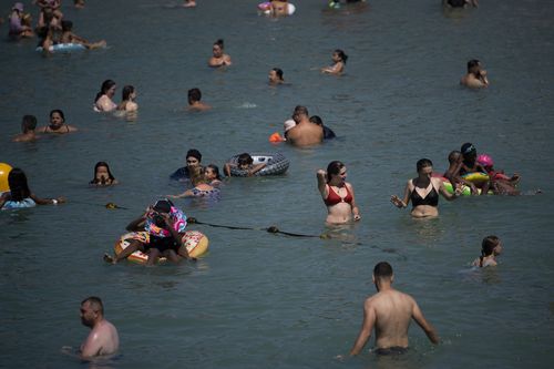 People bathe in the sea during high temperatures in Marseille, southern France, Tuesday, Aug. 22, 2023.