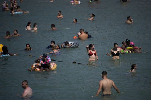 La gente fa il bagno in mare durante l'aumento delle temperature a Marsiglia, nel sud della Francia, martedì 22 agosto 2023.