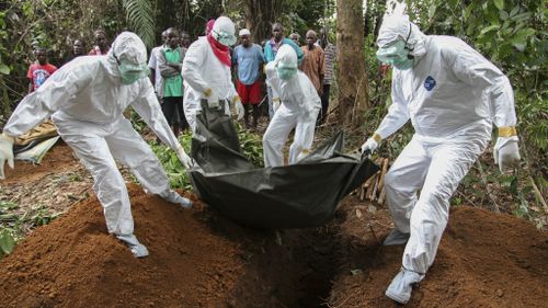 Liberian nurses bury the body of an Ebola victim on the outskirts of Monrovia, Liberia. (AP)