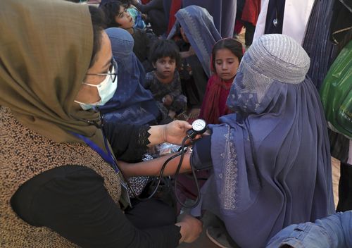 Internally displaced Afghan women from northern provinces, who fled their home due to fighting between the Taliban and Afghan security personnel, receive medical care in a public park in Kabul earlier this month.