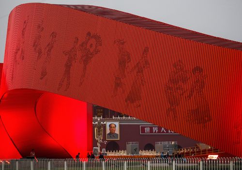 Workers set up near a red ribbon decoration on Tiananmen Square in preparation for the parade for the 70th anniversary of the founding of the People's Republic of China, in Beijing.