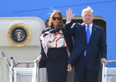 US President Donald Trump tries to hold wife Melania's hand 