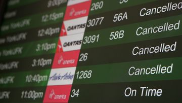 Cancelled flights due to weather are displayed on a departure monitor at San Francisco International Airport